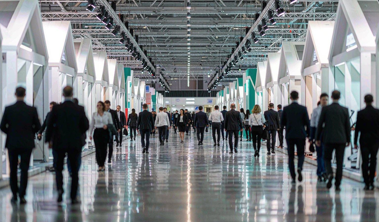 Aisle of a scientific instrument exhibition hall with blurred visitors
